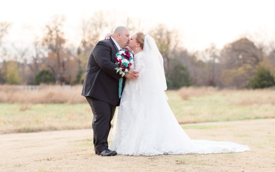 Bride and Groom kissing in a field at Bright Morning Farm in Sand Springs OK. Photo by OKC Wedding Photographer Bill Aycock